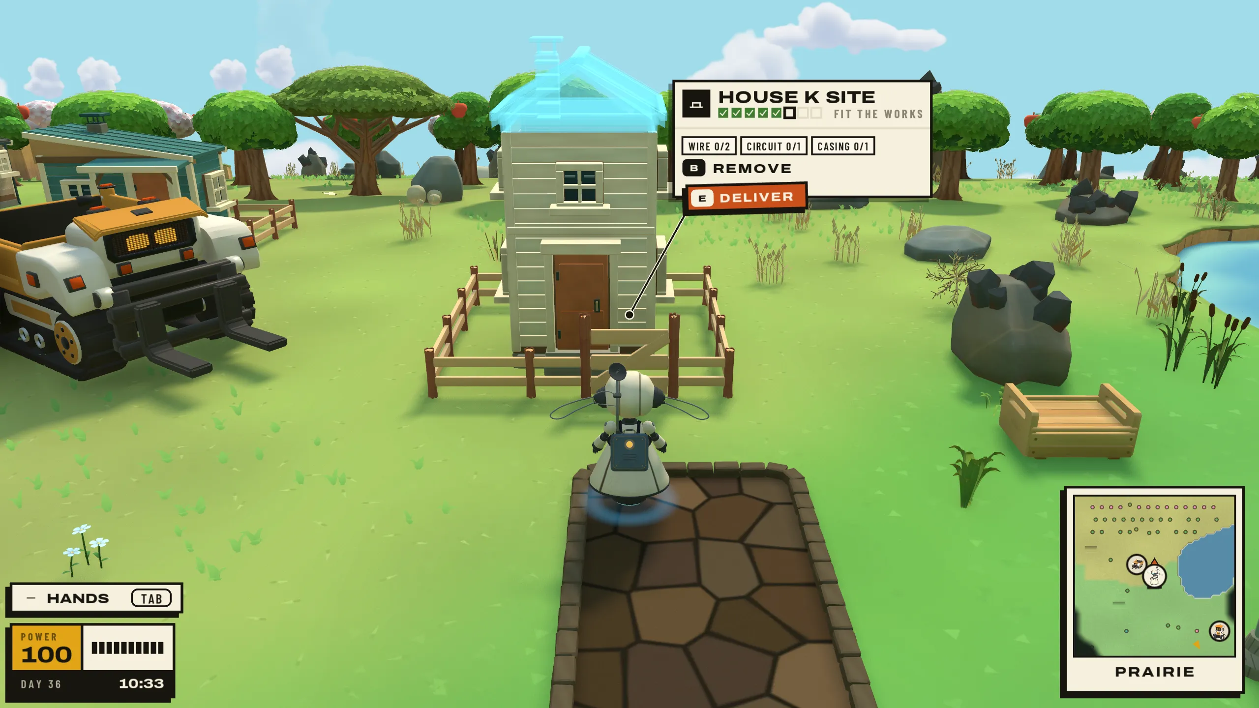 The loaded Hauler waits beside a raised house frame, next to a finished house.